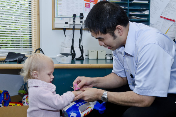 Photo of a clinician giving a young toddler a stamp on the hand.