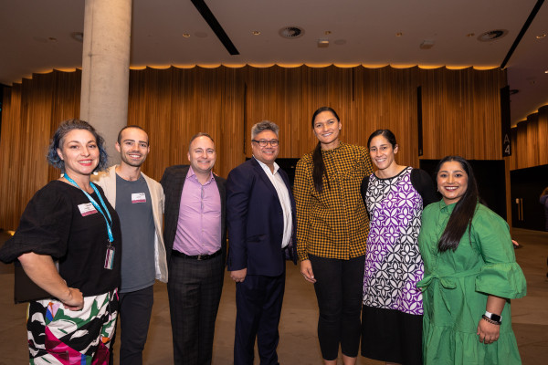 Left to right, Zelda Edwards, Jake Bailey, Deon York, DJ Adams, Dame Valerie Adams, Lauagaia Jeffries, Tanaya Shangarpawar in the Dobson Foyer. They are smiling the camera.