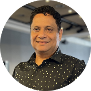 A head and shoulder picture of Vishal. He is wearing a black shirt with collar and small white polka dots. His hair is short and black and one curl crosses his forehead