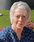 An image of Trish Bloxsom. She has short grey hair and wears a blue top.