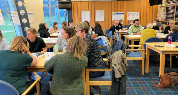 Study day attendees seated around tables in discussion. 