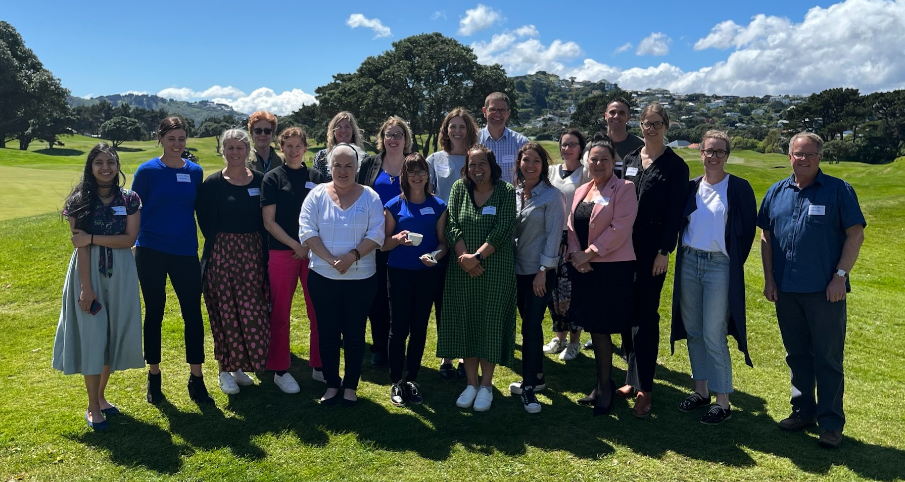 A group of trauma clinicians stand together in a park